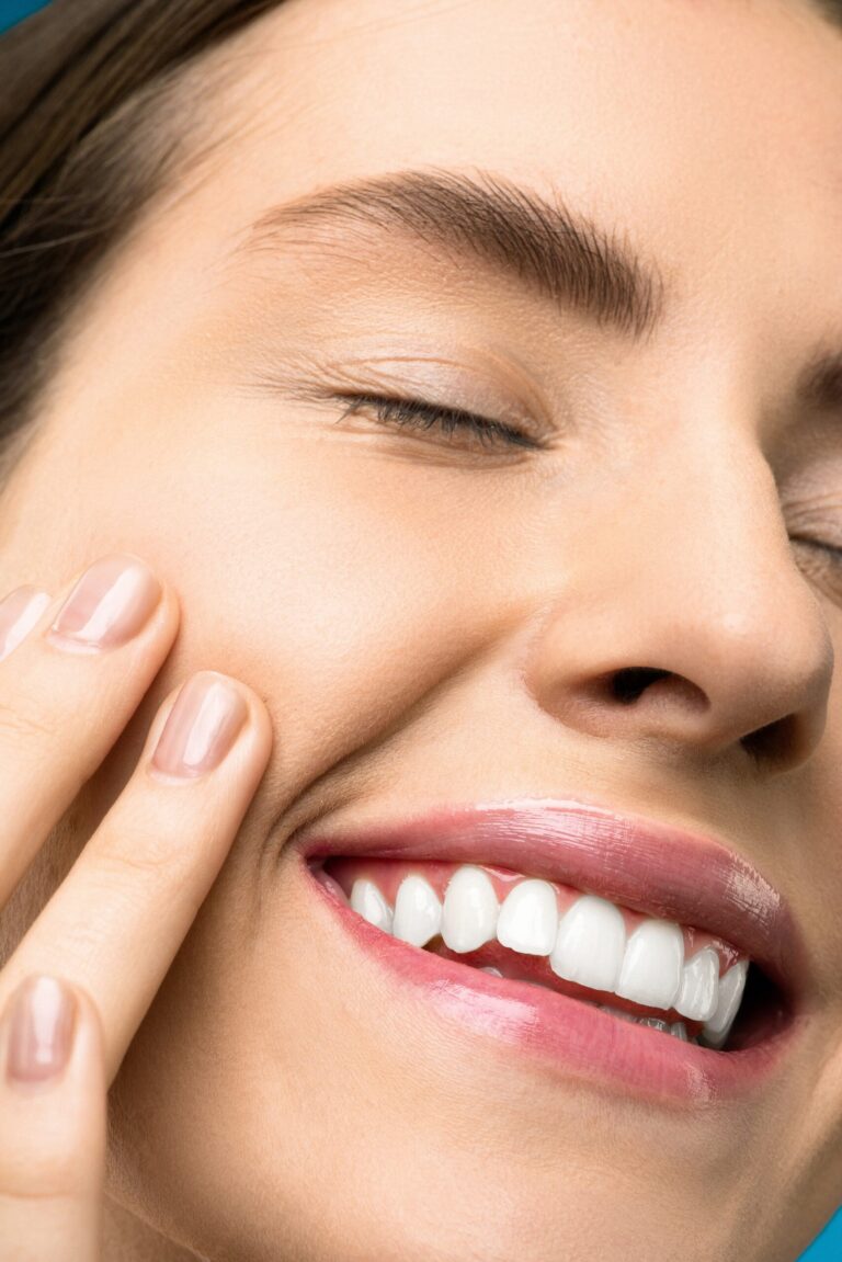 closeup photo of woman with pink lipstick smiling with her eyes closed.